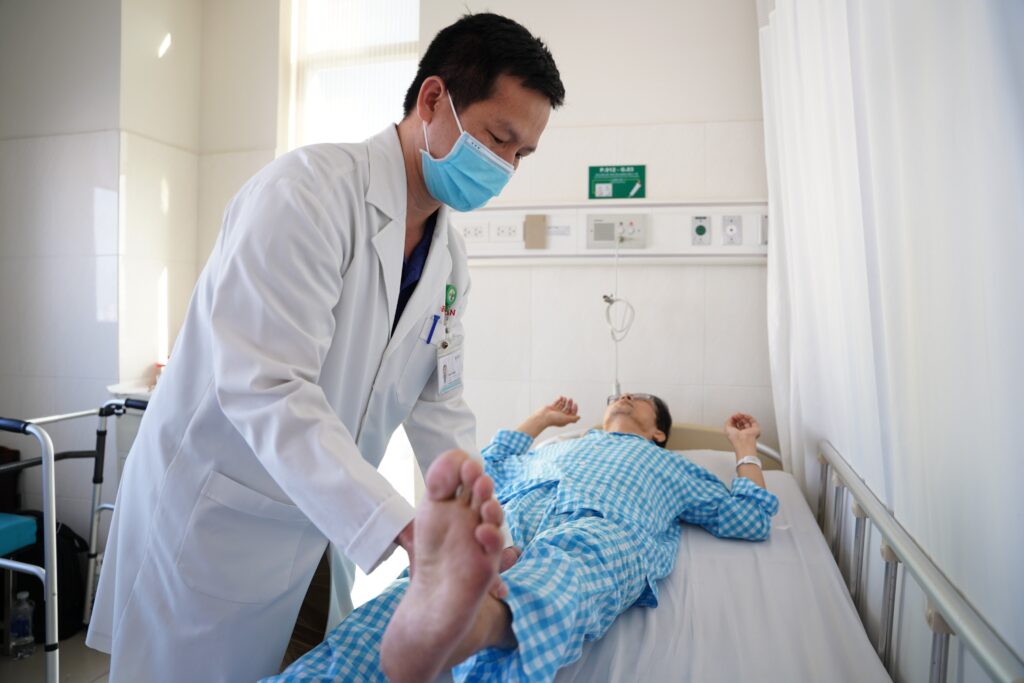 Bác sĩ thăm khám cho người bệnh thoái hóa khớp sau phẫu thuật